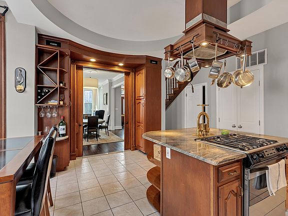 View from the large eat-in kitchen looking towards the formal living room/dining room. Note the pocket doors, built in speakers, and lots of extra storage space including wine rack and wine glass storage.