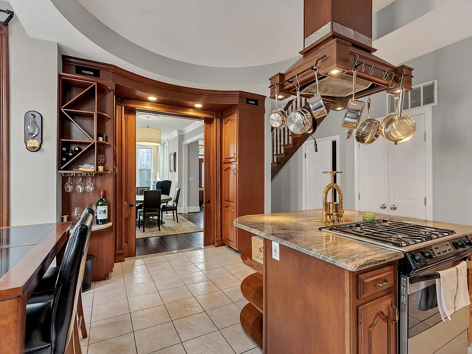 View from the large eat-in kitchen looking towards the formal living room/dining room. Note the pocket doors, built in speakers, and lots of extra storage space including wine rack and wine glass storage.