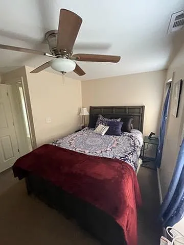 Bedroom with ceiling fan and closet
