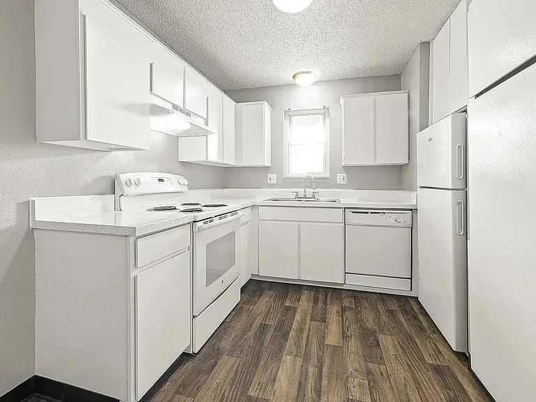 Bright and airy modern kitchen featuring sleek white cabinets, stylish countertops, and elegant wood flooring.