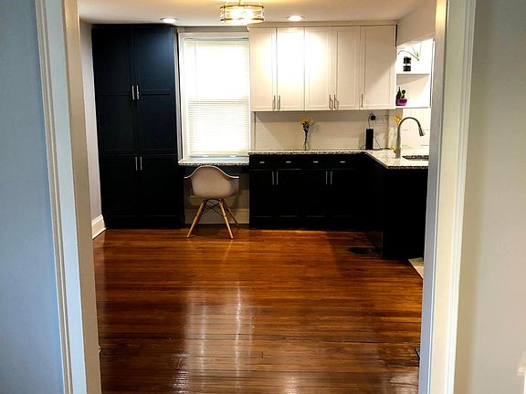 Dining room with hardwood floors and custom dual color cabinets and granite countertops.