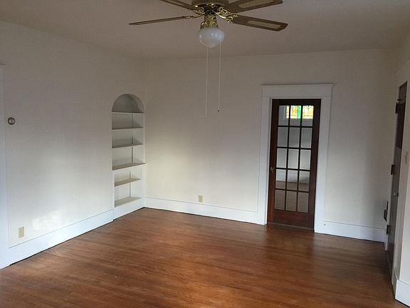 Spacious living room with built in shelves, door shown to fr