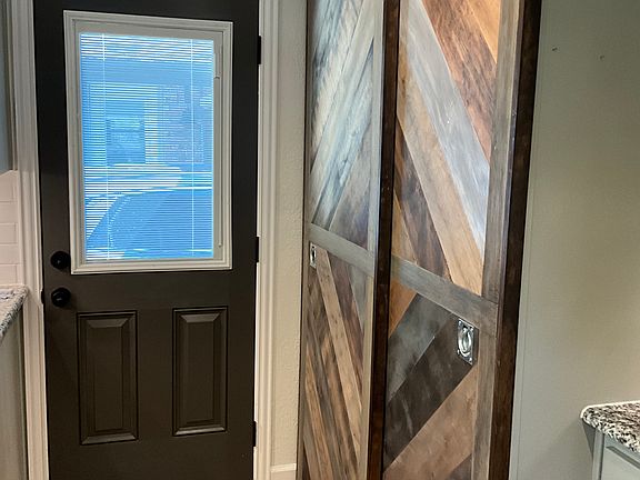 Back entrance view of barn doors into the washer/dryer and pantry