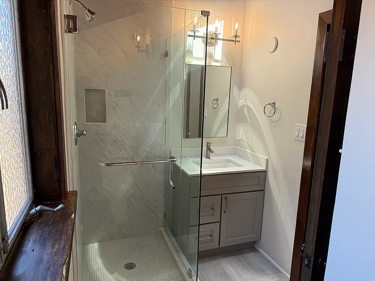 Hallway Bathroom #2 has a shower stall with glass enclosure.