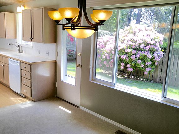 Well-lit dining room and Kitchen with view of back yard.