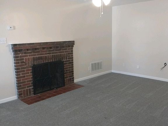 LIVING ROOM AS A NON WORKING FIREPLACE. NEW CARPET AND NEWLY PAINTED WALLS.