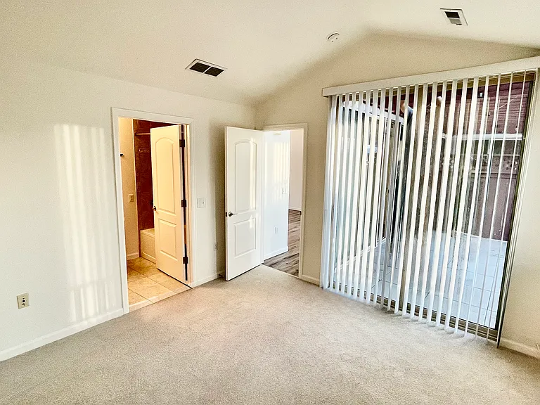Primary bedroom looking at attached deck. Lofted ceilings. No attached walls on any sides to other units.