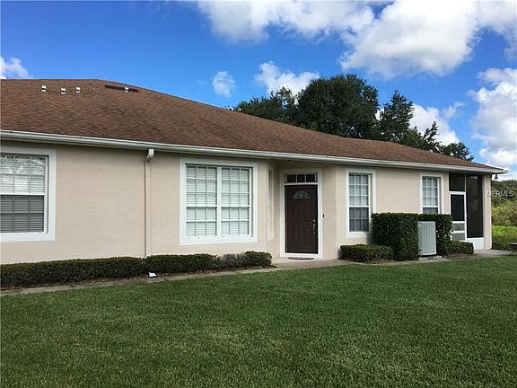 View of Entrance Door & covered patio, hedges, Shingle Roof w/gutters, A/C unit, Screen Lanai, open patio