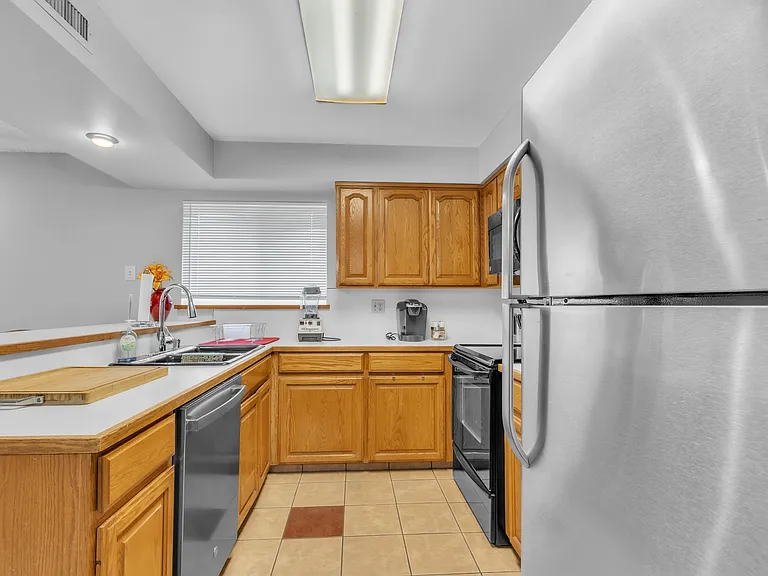 Full kitchen with sink, dishwasher, microwave, Keurig, electric wine opener and refrigerator. Pots, pans and plates.