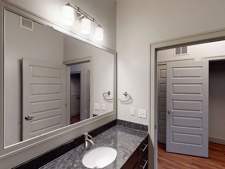 Apartment bathroom with wood-style flooring.