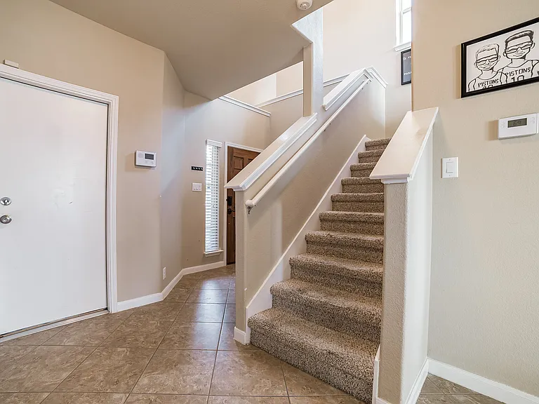 Stairs leading to upstairs with view to the front door entrance