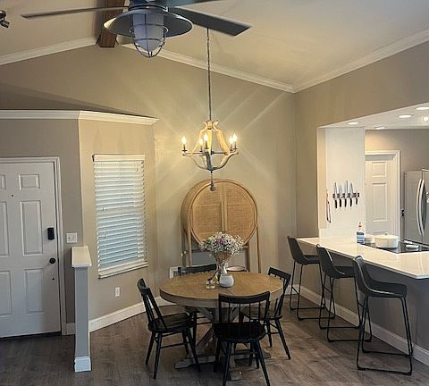 Centrally located between the kitchen and living room, this dining nook with vaulted ceiling and modern chandelier feels airy and open. It comfortably fits a full-size table and offers a warm, social space for hosting dinner parties or casual family meals