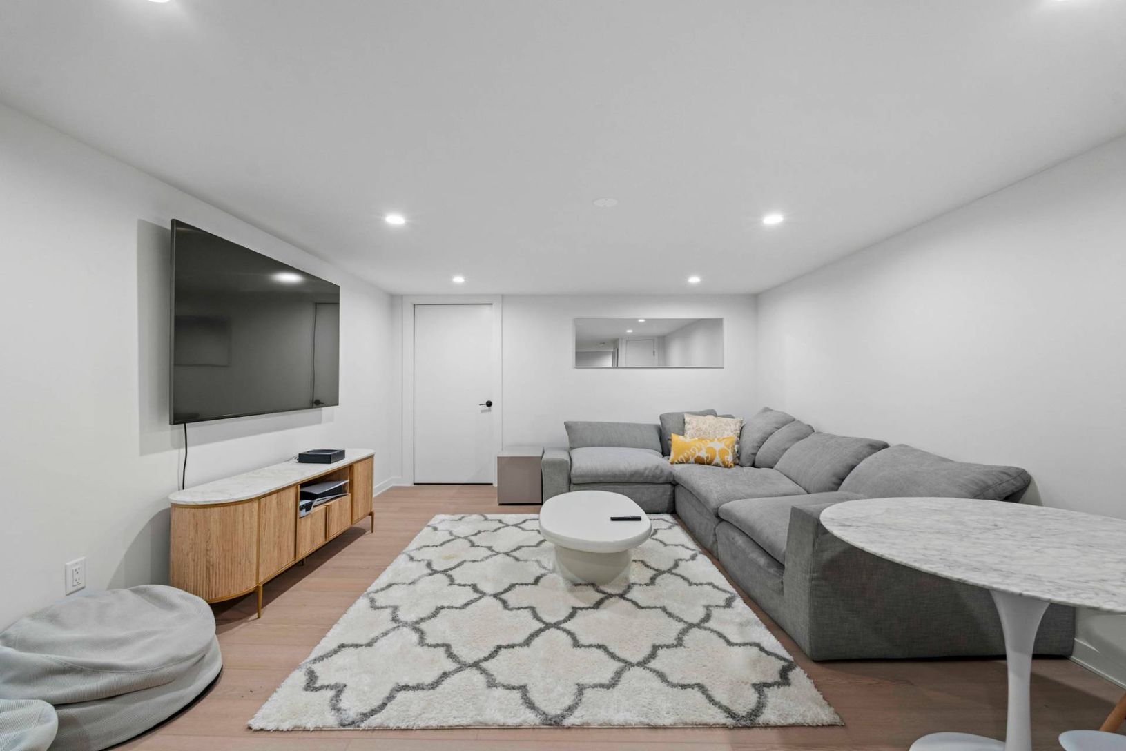 Finished Lower level lounge featuring recessed lighting and light wood-style tile flooring