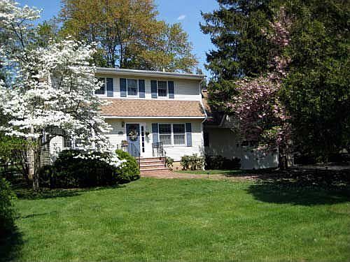 Beautiful flowering trees adorn the front. (Garage with Great Room on right)