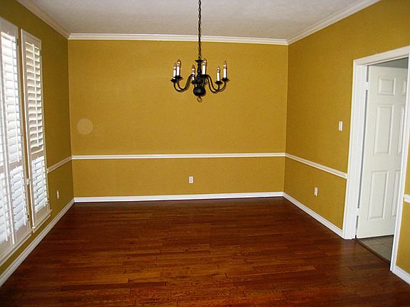 Formal dining room with hardwood floors and plantation shutters.