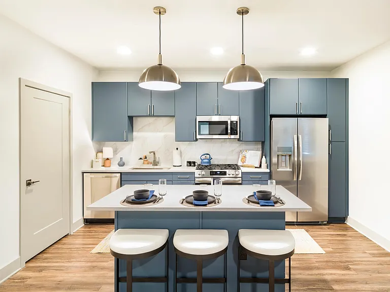 Chef-inspired kitchen with premium finishes, including painted cabinetry, stone-inspired surfaces, stainless steel appliances, and statement pendant lighting.