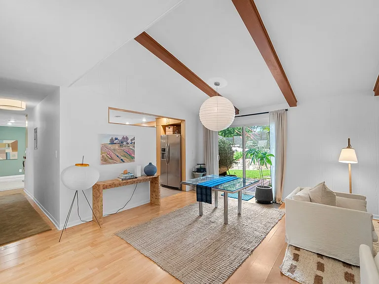 View from front entry. Hall on left to another secondary bedroom, primary bedroom & dining.