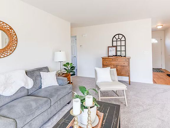 Living room. Front entrance in background on the right. Hallway to bedrooms and bathrooms on left.