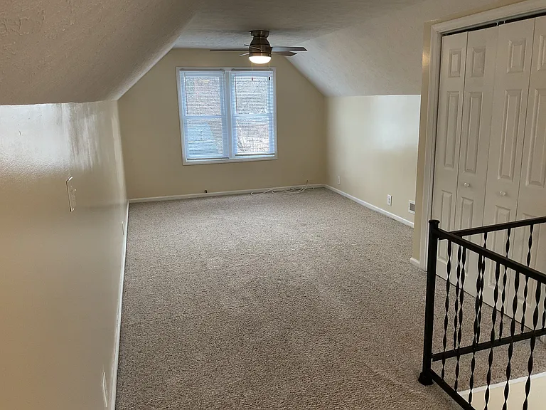 Upper Bedroom has a ceiling fan and lots of space.