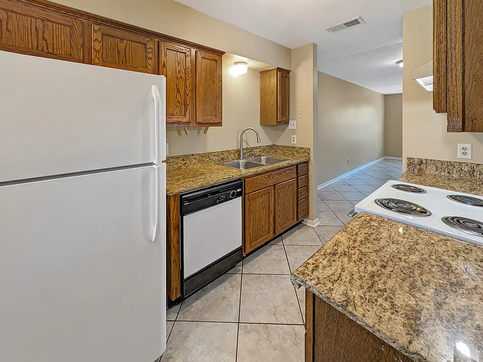 Updated kitchen with granite counters and white appliances at 1811 Woodsman Dr Unit C.
