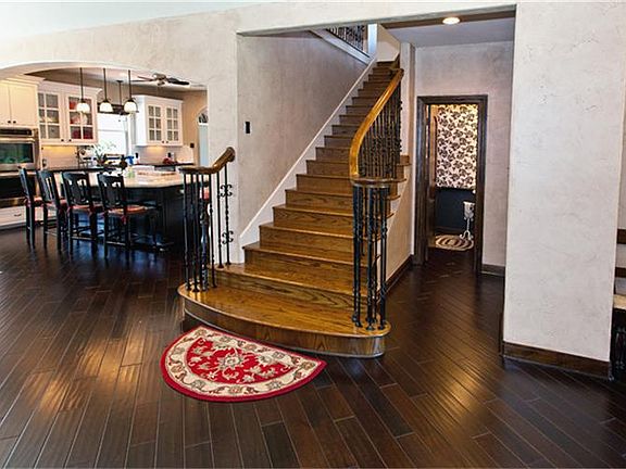 Stairway leads to a bedroom, full  bath with black granite counter tops, and vanity with a shower/tub combination and custom tile floors