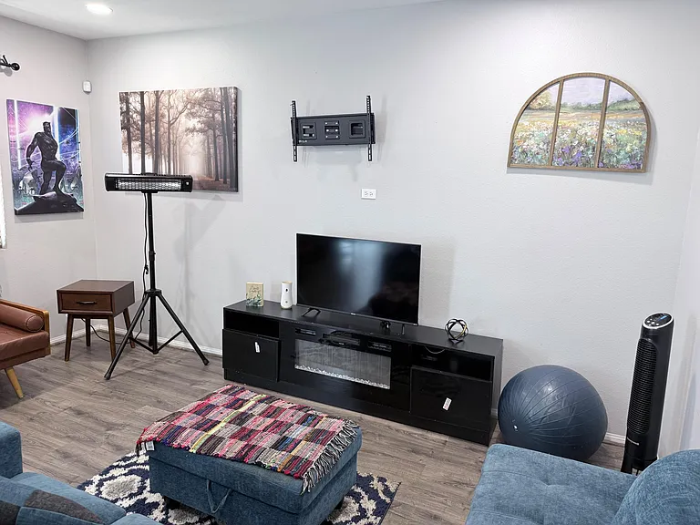 Shared living area with lounge seating, TV console and open floor spaceideal for relaxing, studying, or movie nights.