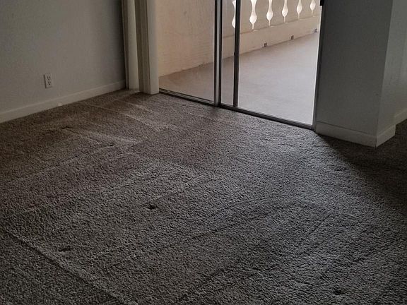 Den with sliding glass doors to balcony