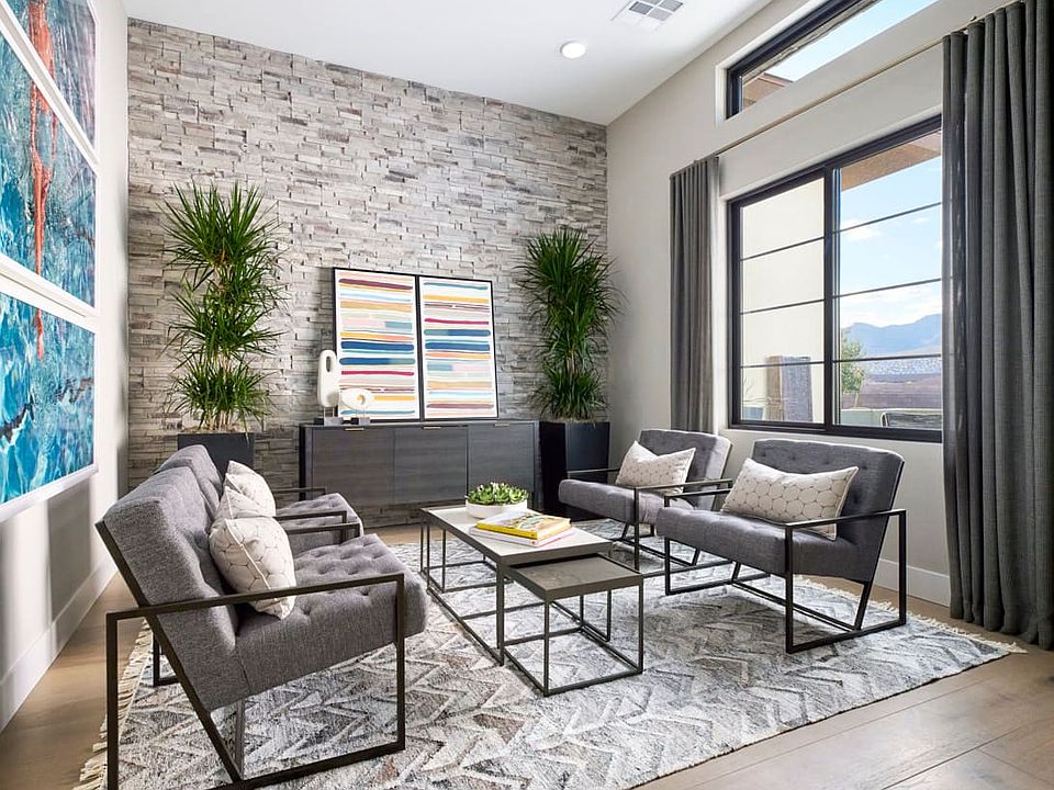 A modern and stylish living room with a stone accent wall, comfortable gray furniture, and a pattern