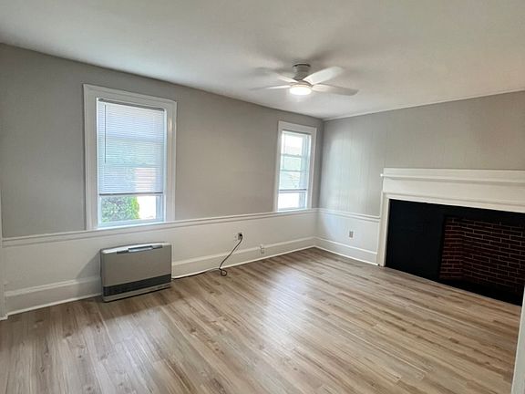 View of living room and entrance from the bedroom - high ceilings, large fireplace and lots of natural light