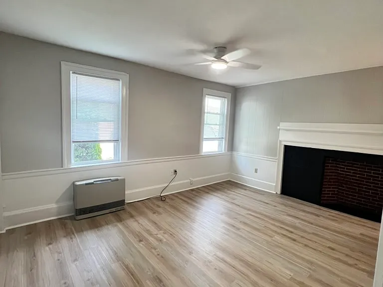 View of living room and entrance from the bedroom - high ceilings, large fireplace and lots of natural light
