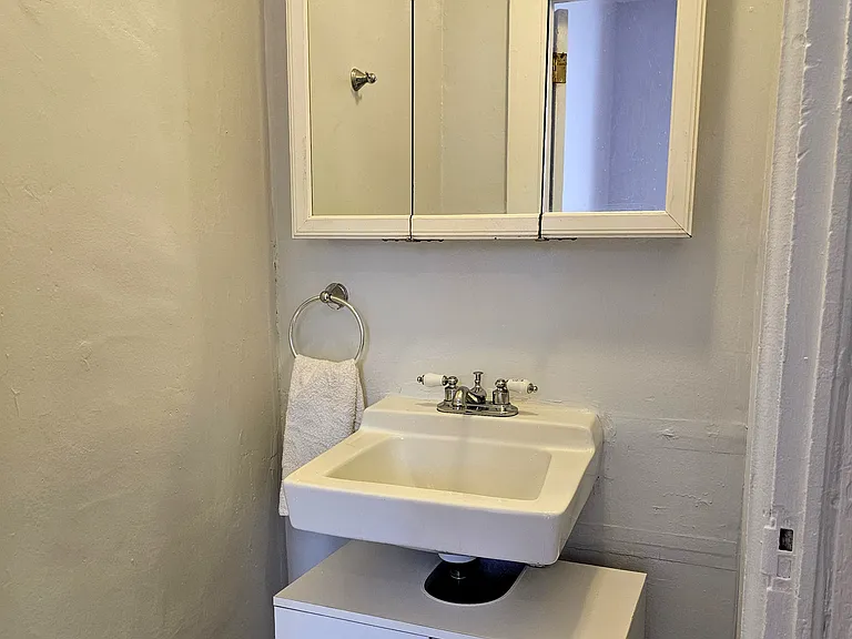 Bathroom sink and vanity with storage cabinetry.