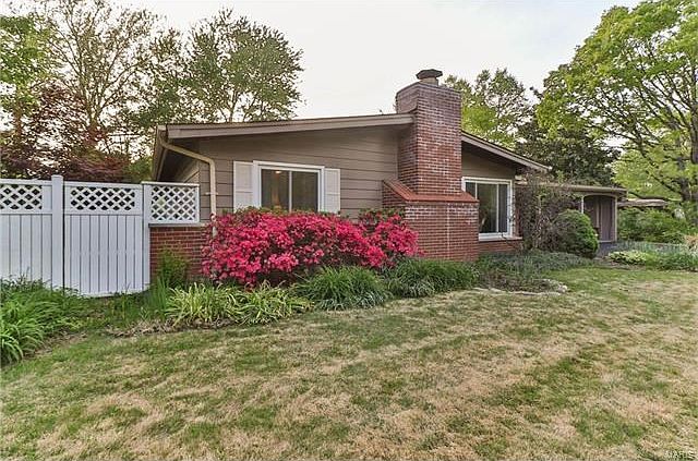 737 Pebbleshire in the early spring.  Beyond the fence is an herb garden adjacent to the kitchen.  The kitchen is large enough to  accommodate more than one cook with an area for the family to gather. This home is located on one the largest level lots in 