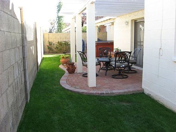 Backyard with brick patio and lush green lawn