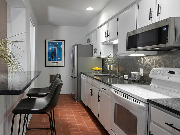 Galley style kitchen with granite counters & breakfast bar
