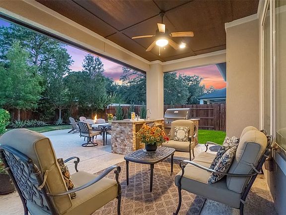 Entertainers backyard featuring pool and spa, covered patio, fire pit, and outdoor kitchen.