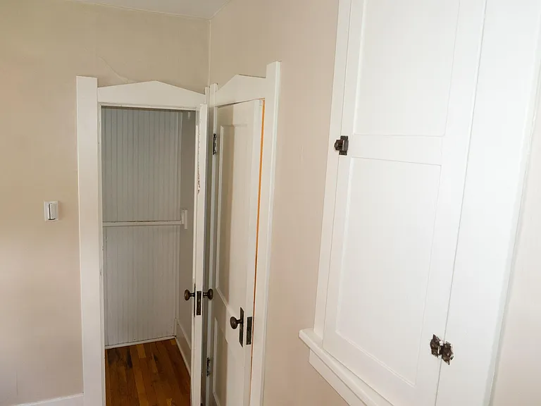 Closet in the back bedroom. Measures ?? X ?? has two clothes rack bars, and high shelf above those.