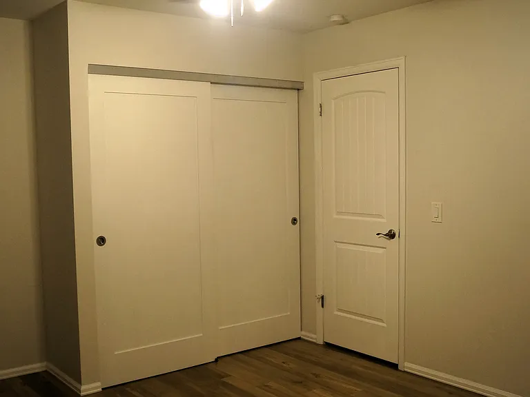 Primary bedroom closet and entry door.