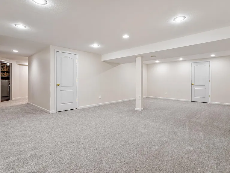 large basement family room with closet with shelves for games