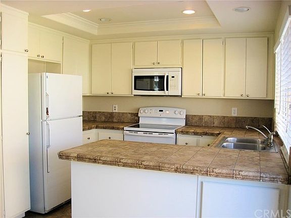 Stone look ceramic tile counters and floor in the kitchen, recessed lighting and freshly painted cab