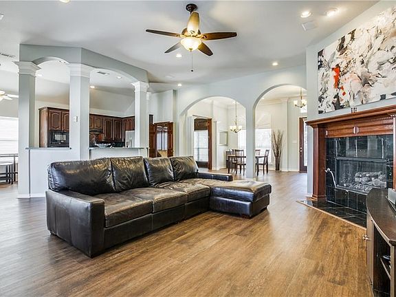 Open concept with gas logs. Kitchen looks directly into the dining and living area plus the outdoor pool and grassy back yard.