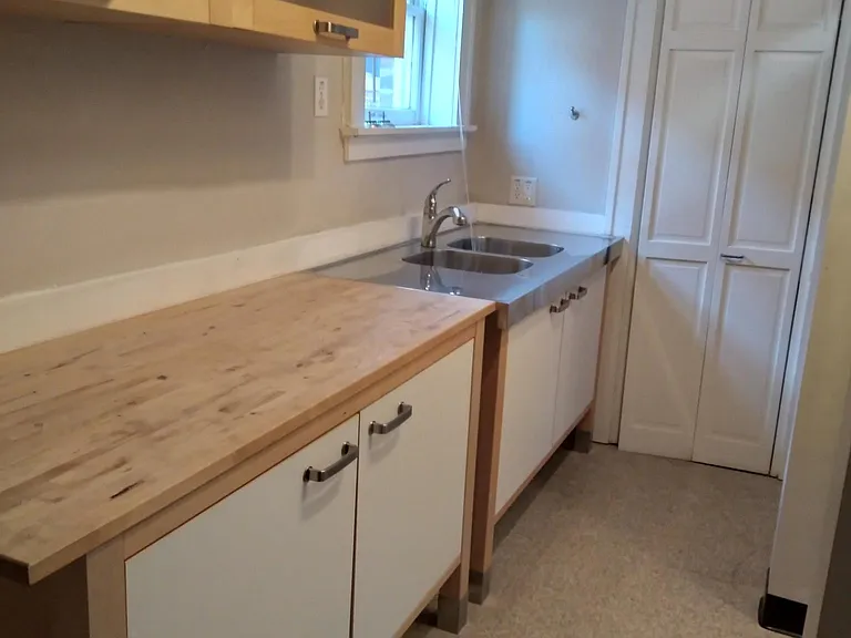 Kitchen area with sink, shelving, refrigerator, and stove