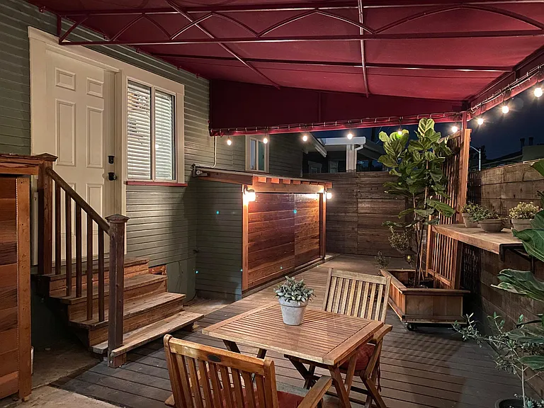 Storage shed shown on right. Washing machine and dryer enclosure on left of stairs.