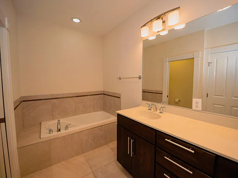 Master bathroom with jetted tub and separate enclosed toilet closet