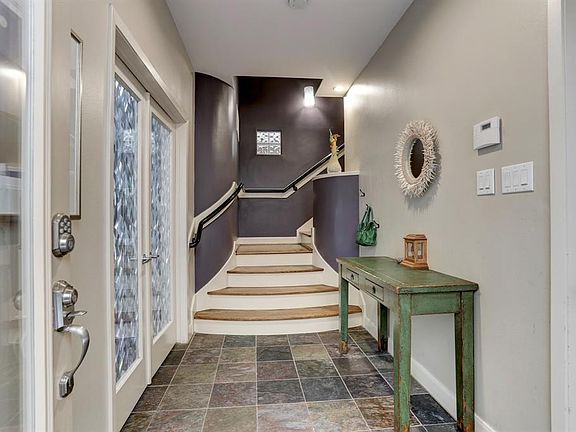 Slate tile front entry foyer with oak hardwood stairs leading to the second floor directly ahead, and french doors leading to th