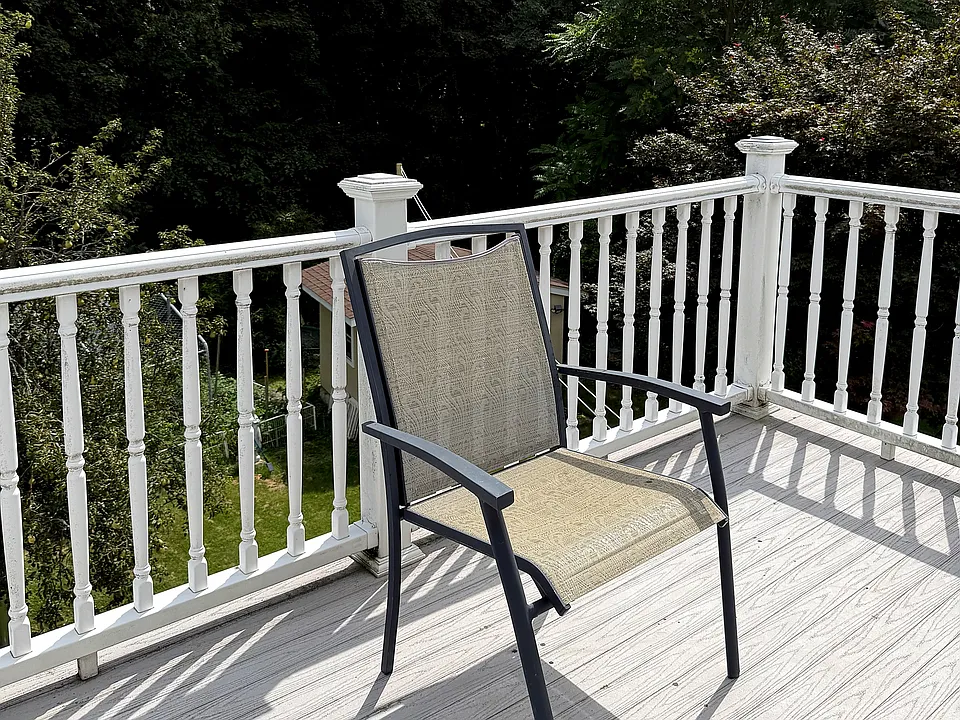 Private deck off the kitchen_no houses behind, just trees. Room for a table and chairs.