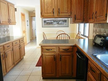 View of kitchen looking towards hallway and dinette area.  Refrigerator and stove are staying.