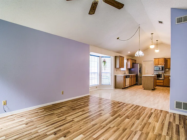 and a view of the kitchen from the family room with more large windows on the left.