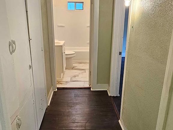 Hallway with pantry storage leading from the kitchen to the bedroom and bathroom.