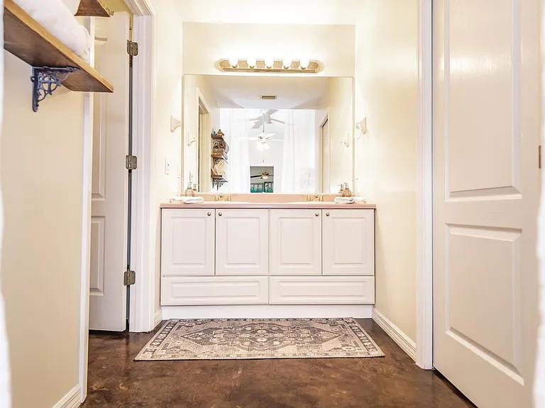 Double sink. Room to left - toilet and tub/shower unit. Room to right - large walk-in closet.