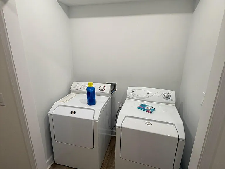 Dedicated laundry nook with side-by-side washer and dryer, plus a built-in shelf for detergents and supplies.